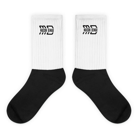 White socks with black soles and 'Maison Demar' logo on a white background